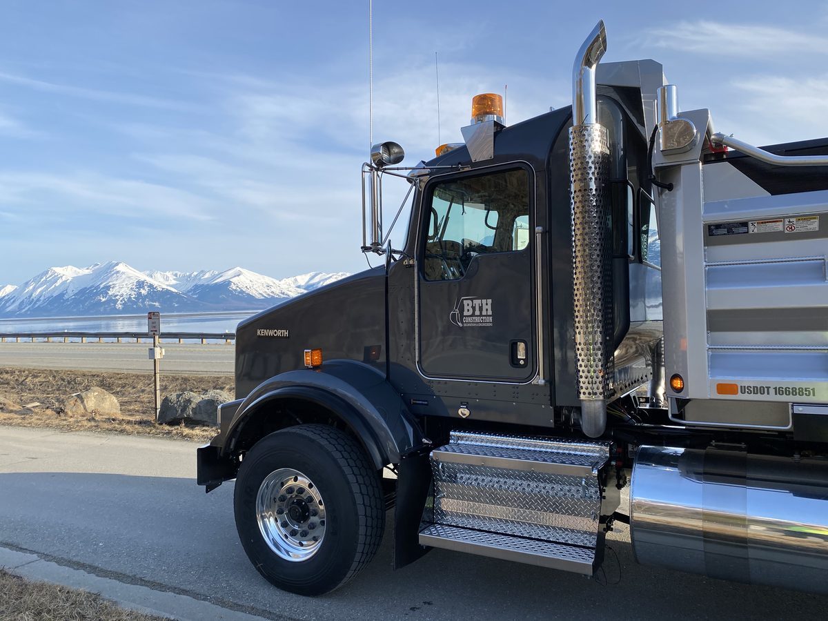 BTH Construction Kenworth dump truck on Seward Highway with Turnagain Arm and Chugach mountains, Alaska